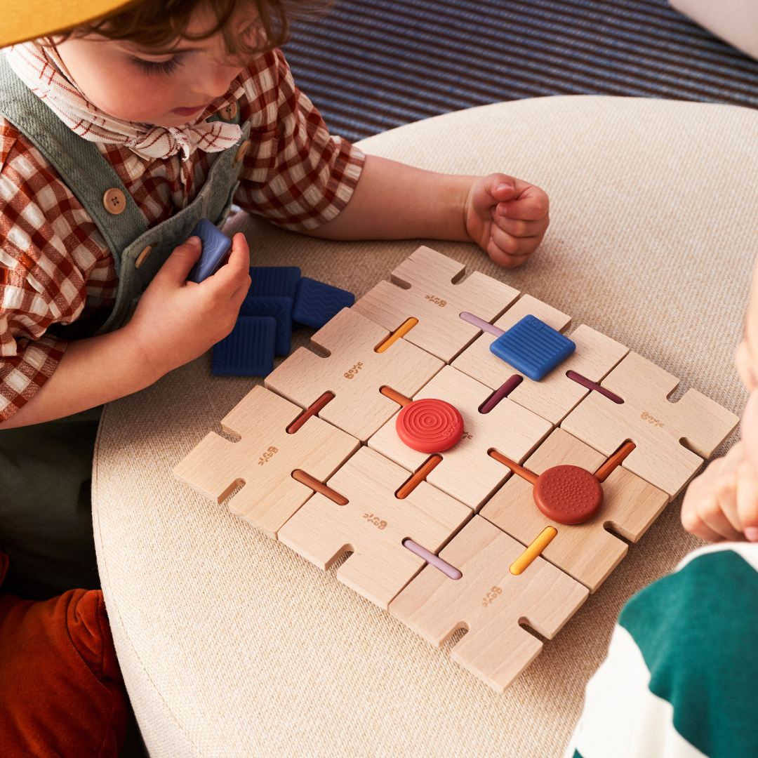 Child plays a grid game with BAVVIC wooden building blocks and silicone pieces — creative STEAM toy