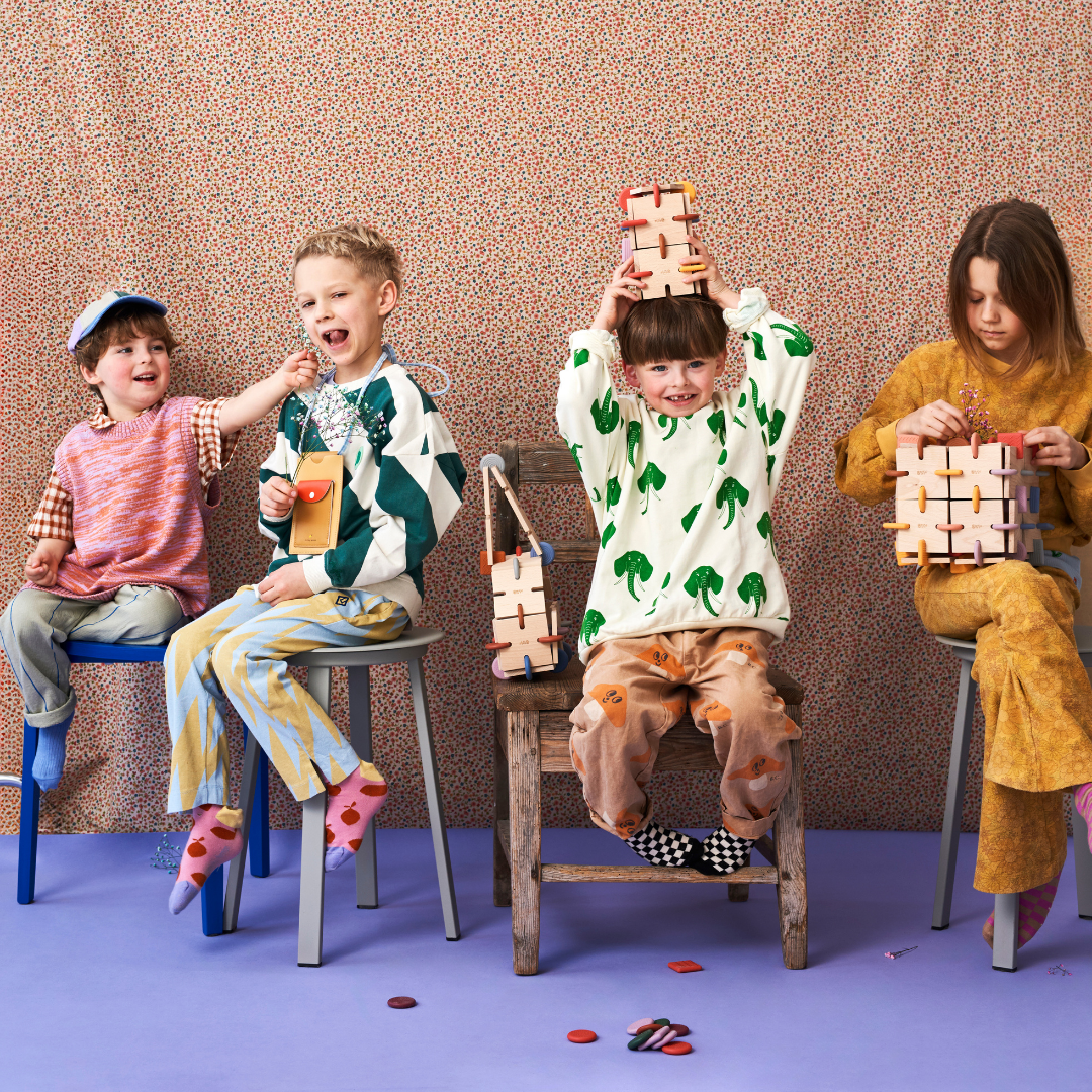 Four children play with BAVVIC wooden building blocks in a row — group STEAM construction toy fun