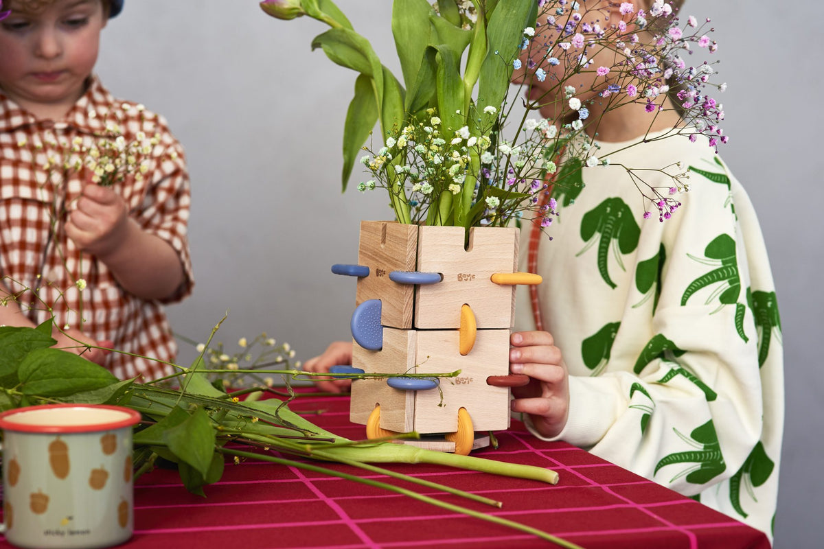children focused on building with BAVVIC wooden blocks